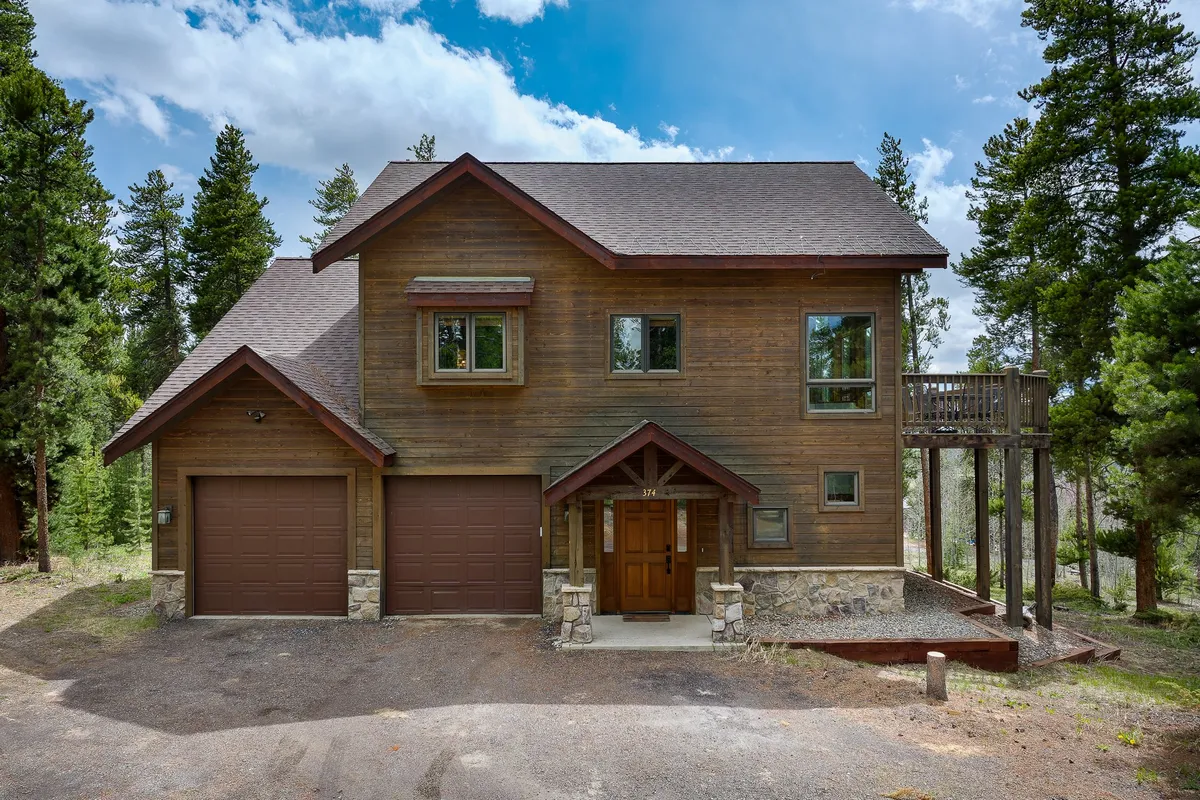 This image shows the welcoming wooden exterior of Silver Lining Lodge, featuring large windows, a front porch, and rustic stone accents. The scene captures the lodge surrounded by natural beauty—perfect for family gatherings, watching sunsets, and enjoying the outdoors together.